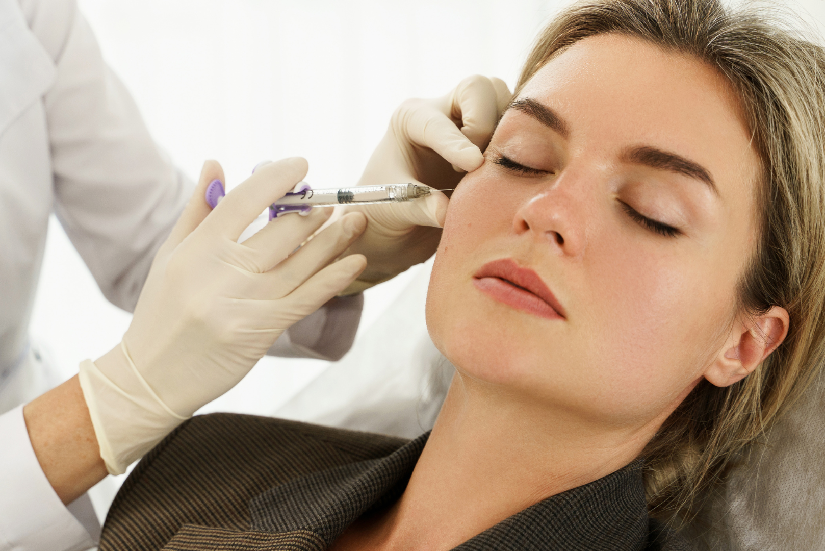 Beautiful woman getting dermal fillers to correct age-related volume loss in the face for natural-looking results.